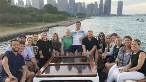 A group of people on the top deck of a charter yacht overseeing Chicago IL